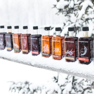 Runamok maple syrups lined up in snow