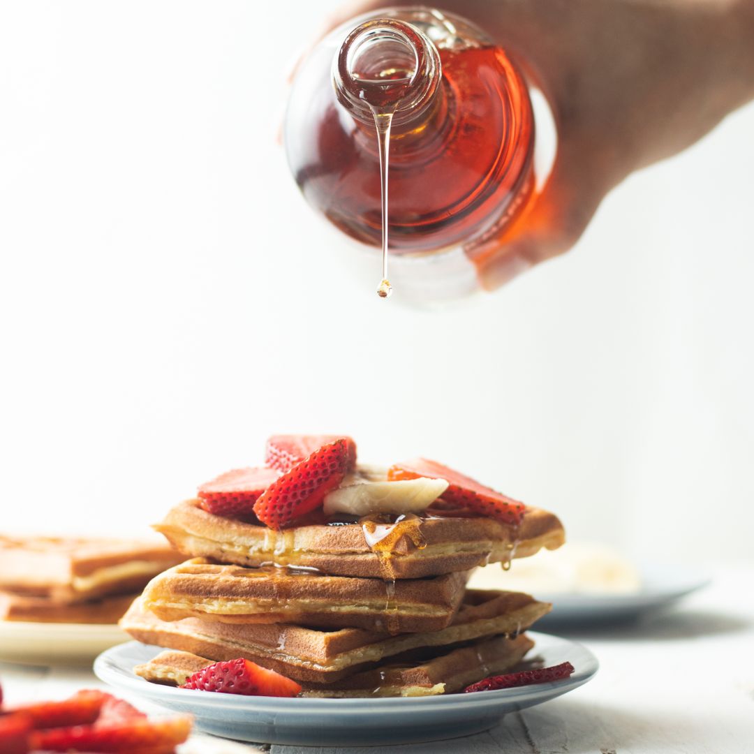 Sugarmaker's Cut pouring over a stack of waffles with strawberries; photo credit: Samuel Kaufman